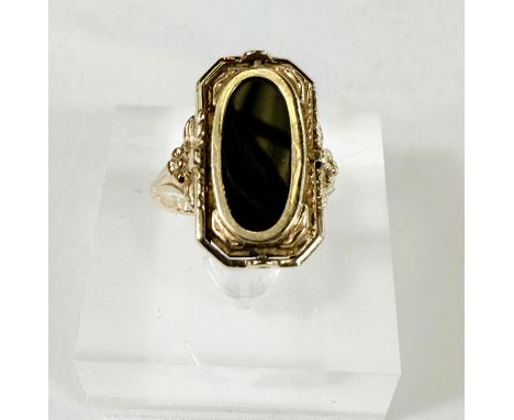 A yellow metal ring set with a swivel alternating cameo and obsidian coloured stone, unmarked, 4.4gms, size M