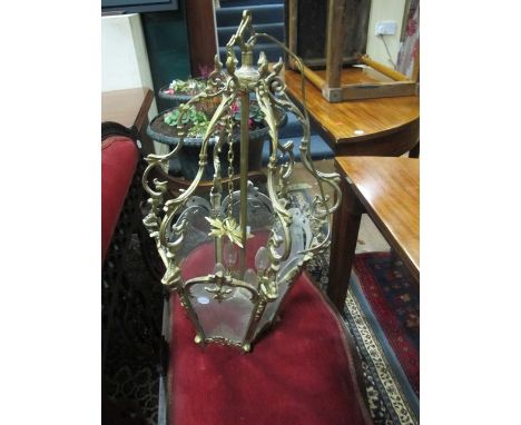 A BRASS FOUR LIGHT LANTERN of octagonal form with glazed panels and scroll arms 