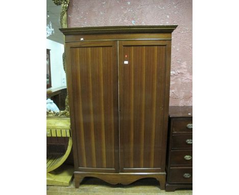 A MAHOGANY CUPBOARD the dentil moulded cornice above a pair of panelled doors opening to reveal a shelved interior on bracket