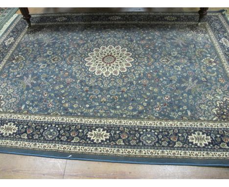 A WOOL RUG the light blue ground with central floral panel with conforming border 295cm x 200cm
