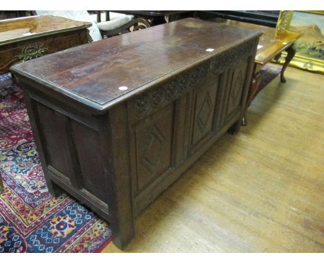 AN OAK TRUNK 19th Century the rectangular hinged lid above a carved frieze on square block feet 72cm (h) x 127cm (w) x 52cm (