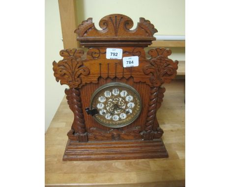 AN EDWARDIAN PITCH PINE MANTLE CLOCK the carved case with circular dial raised on a rectangular stepped base 43cm x 35cm