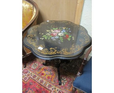 A BLACK LACQUERED AND POLYCHROME TABLE the shaped moulded top with floral panel's and gilt C scroll border raised on baluster