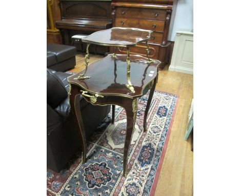 A FRENCH KINGWOOD AND GILT BRASS MOUNTED ETAGERE surmounted with a serpentine shelf above a conforming base joined by scrolle