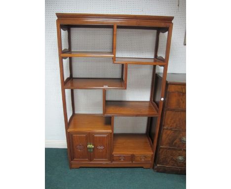 A CHINESE HARDWOOD SIX TIER OPEN FRONT SHELF the rectangular top above stepped shelves the base with cupboards and drawers on