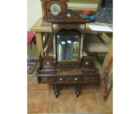 A MOORISH STYLE OVERMANTLE MIRROR the arched pediment above a rectangular bevelled mirror with open shelf and frieze drawer o