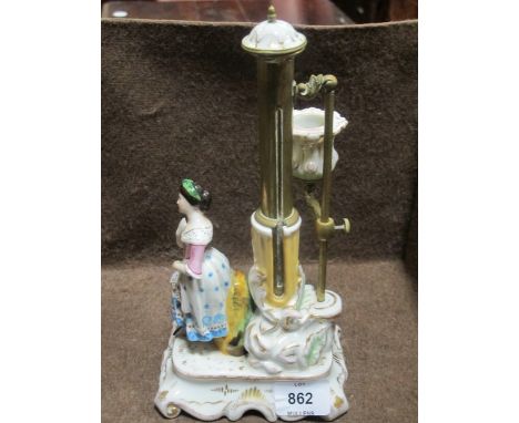 A GERMAN PORCELAIN BRASS CHAMBER STICK with adjustable sconce and scroll base with figure shown standing 25cm high