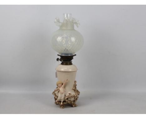 A vintage oil lamp, the base with applied putti amid branches, with chimney and vaseline glass shade, approximately 55 cm (h)
