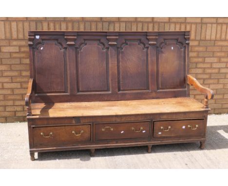 An oak box settle with four panel back, open arms and three drawer box seat, approximately 122 cm x 181 cm x 66 cm.