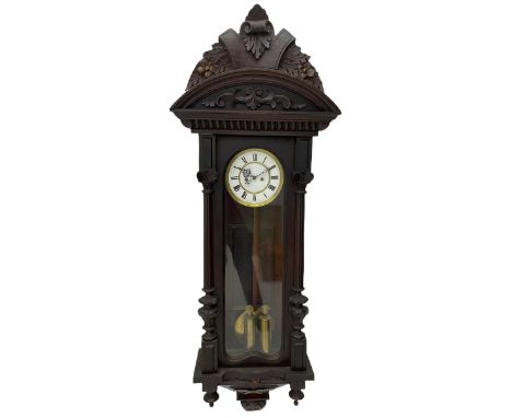 A late 19th century German Vienna style weight driven wall clock c1880, with a predominant arched pediment and applied carvin