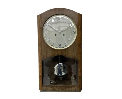 A mid 20th century German wall clock in a veneered mahogany case with a German eight day 'Kienzle' movement sounding the hour