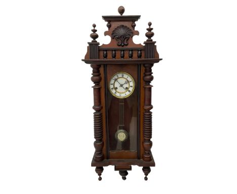 A  German spring driven wall clock c1900 within a glazed case with side panels and a full-length arched door and ornately car