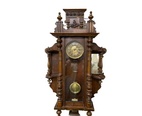 An imposing early 20th century German mahogany cased wall clock c1910, within a shaped surround with turned columns incorpora