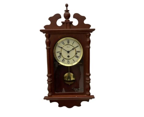 A contemporary 21st century wall clock in a mahogany finished case with a fully glazed door, two-part dial with Roman numeral