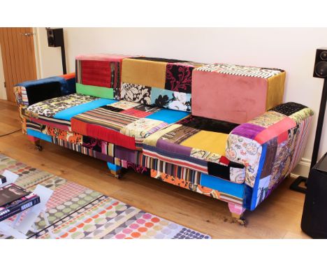 A bespoke three-seater sofa by Lisa Whatnough of Squint Limited - with rectangular box back-cushions, upholstered in panels o