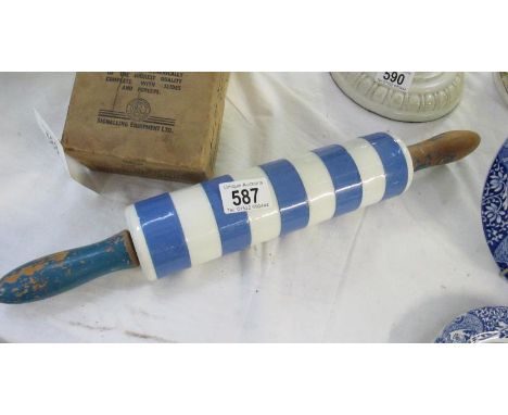 A vintage china blue and white hooped rolling pin with wooden handles