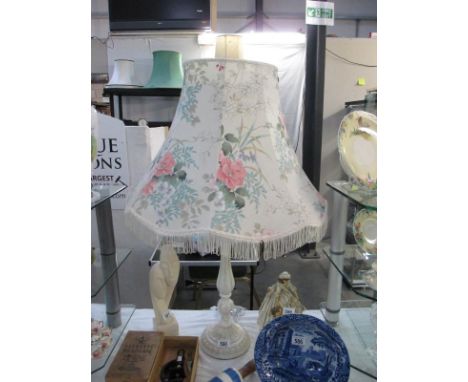 A large white wooden based table lamp