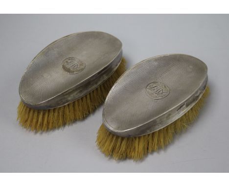 A pair of 1920's engine turned silver mounted clothes brushes by Walker & Hall, Sheffield, 1929, 14cm.