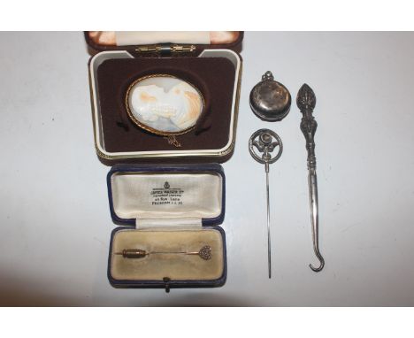 A yellow metal stick pin; a silver handled button hook; a silver hat pin; a silver Sovereign case and a cameo brooch 