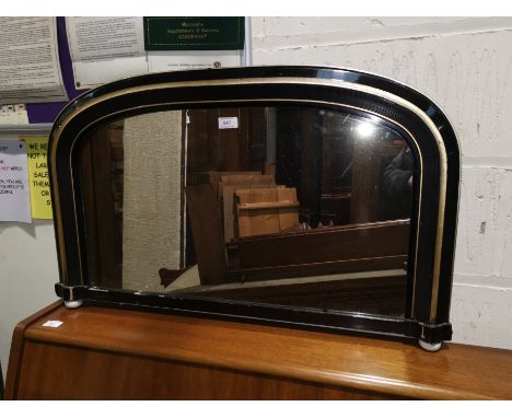 An arch top overmantel mirror with ebonised and gilt border and a shield shped brass mirror 