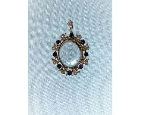 An Edwardian yellow metal oval locket/pendant, glazed, the ornate border set with seed pearls in teardrop mounts interspersed