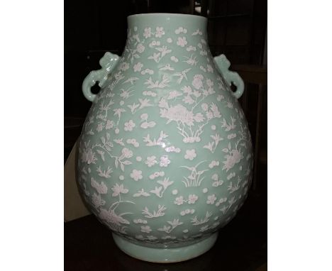 A very large Chinese ceramic vase with celadon glaze and raised white floral and naturalistic decoration, with 2 stands, heig