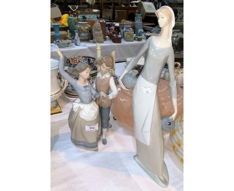 A Lladro group:  2 children dancing, height 32 cm; a Nao figure:  female water carrier, height 42 cm 