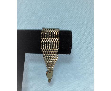 A wide yellow metal gate bracelet, stamped '375', 20 gm 