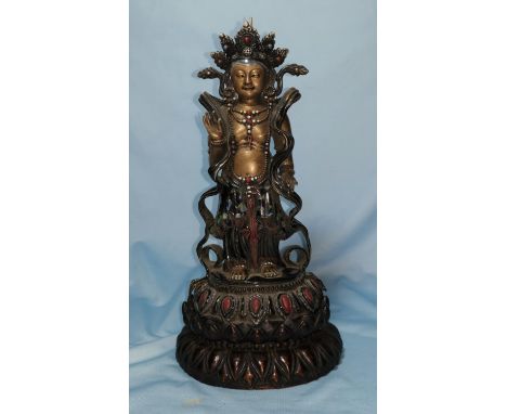 An oriental ceramic figure of Buddha decorated in gilt, etc., on wooden stand 