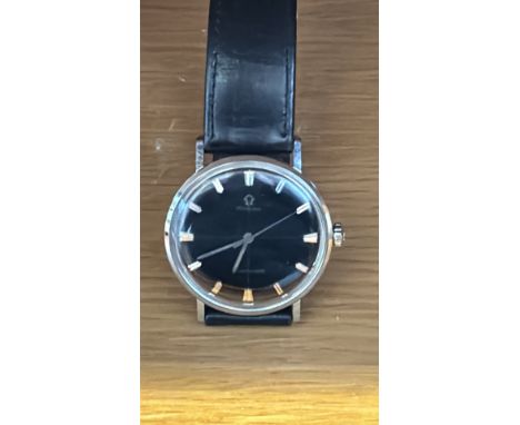 Vintage Omega Seamaster wristwatch features a black dial with baton indices and sweep second hand. It has a stainless steel c