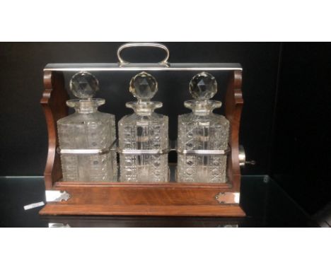 Walker & Hall Sheffield, The only 'HOLDFAST' patent Victorian oak and silver-plated tantalus with three cut-glass decanters a