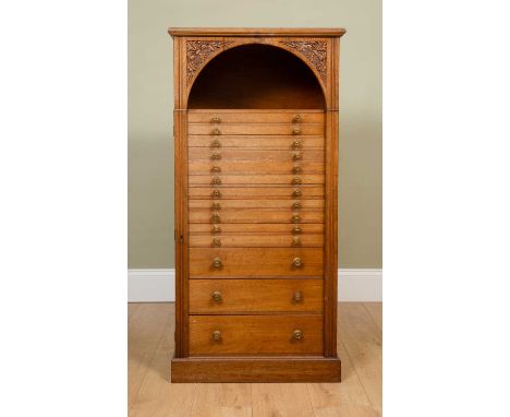 A late Victorian mahogany collectors cabinet or Wellington chest with fourteen graduated drawers beneath an arched recess wit