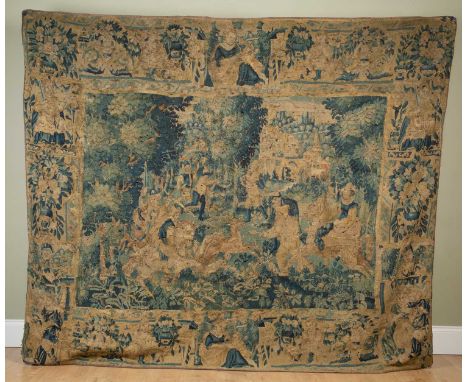 A 17th or 18th century Flemish tapestry depicting courtly figures hunting a stag before a large country house, all within a b