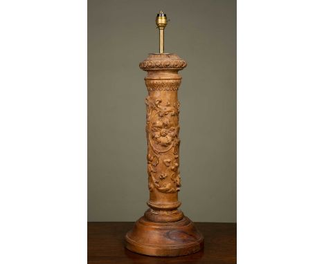 A carved wooden table lamp of columnar form, decorated with flowers and on an associated spreading circular base, 21cm diamet