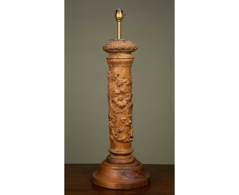 A carved wooden table lamp of columnar form, decorated with flowers and on an associated spreading circular base, 21cm diamet