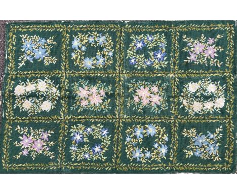A green ground floral embroidered needlework 146cm x 95cmSome patches of wear to the tapestry and slightly pulled at the edge