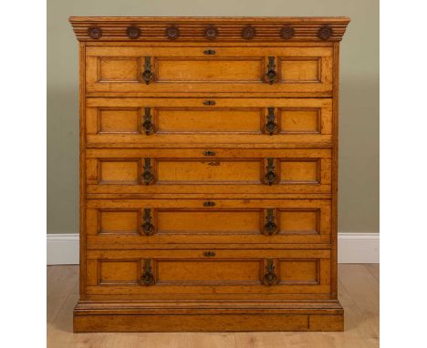 A Victorian aesthetic-style oak chest of five long drawers, the deep frieze decorated roundels above drawers with looping han