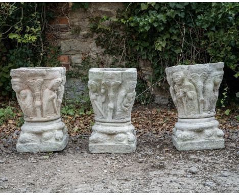 A set of three cast reconstituted stone ornaments or planters in the form of a Celtic capitol decorated with figures, and on 