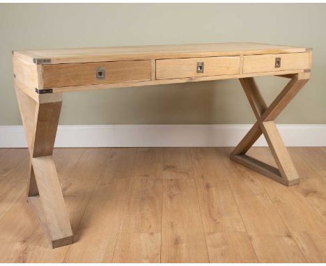 A modern oak desk, the three drawers with inset handles, on X-frame trestle supports, 145cm wide x 55cm deep x 79cm highSome 