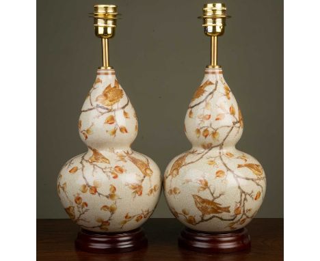 A pair of ceramic table lamps of double gourd form, decorated with birds amongst foliage and a crackle glaze finish, on a cir