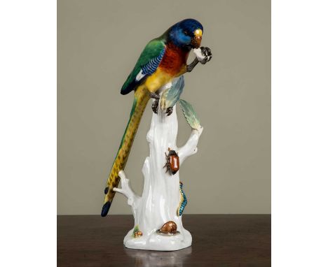 A late Meissen model of a parrot perched on a tree stump, impressed with a model number '20' beneath and with underglazed blu