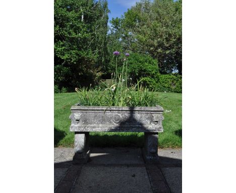 A cast reconstituted stone rectangular trough with lion mask ornament and on supports decorated with acanthus leaves, 91cm wi