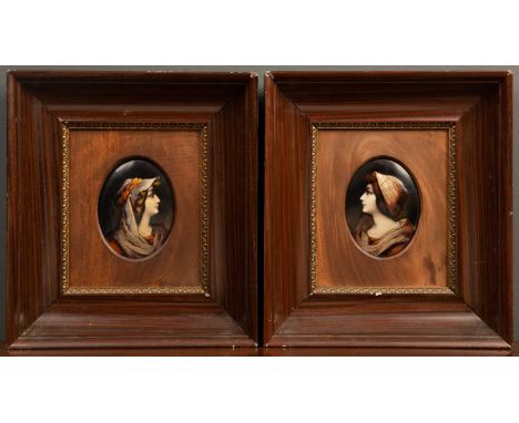 A pair of oval Limogues enamel plaques depicting young women, signed with a monogram, late 19th Century, with a label to the 