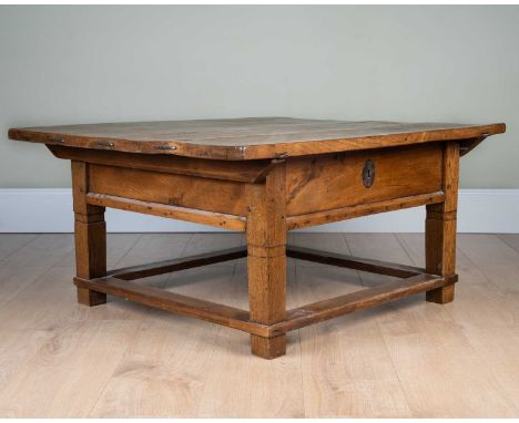 A oak occasional table with sliding top, with plank top over single drawer, on square supports united by perimeter stretcher,