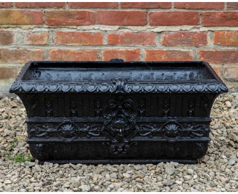 A black painted cast iron trough of rectangular form, decorated with cherub masks and on cast iron supports with female mask 