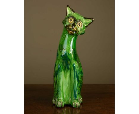 A Brannam ceramic green cat, with yellow glass eyes, signed to the base 'C. H. Brannam' and dated 1911, 27cm highCrazing to t