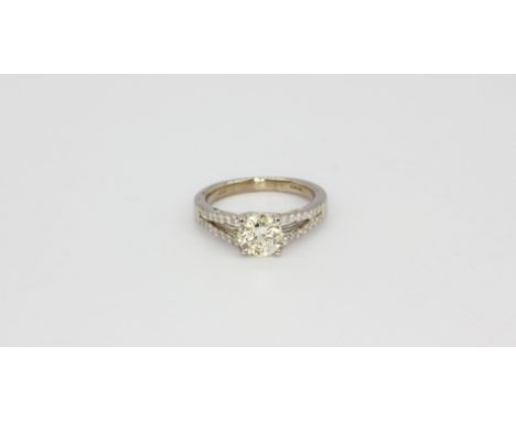 An 18ct white gold solitaire ring set with an apporx. 1ct brilliant cut diamonds and diamond set shoulders, (K).