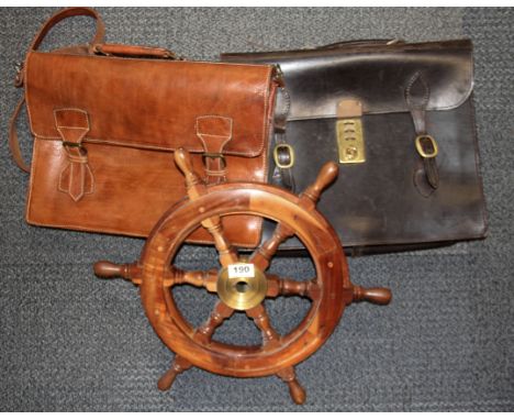 Two vintage leather attache cases and a wooden ships wheel.