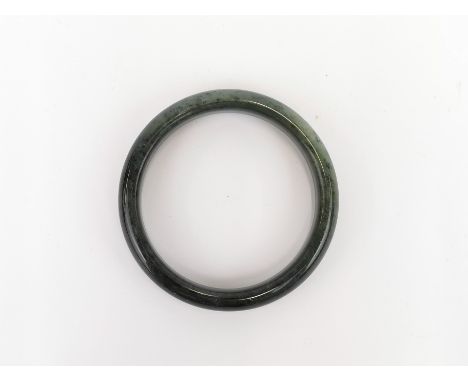 A grey green mottled jade / hardstone bangle, internal dia. 5.8cm.