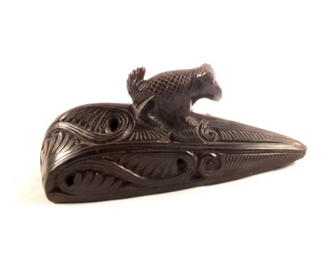 A carved item with animal finial and holes for attachment